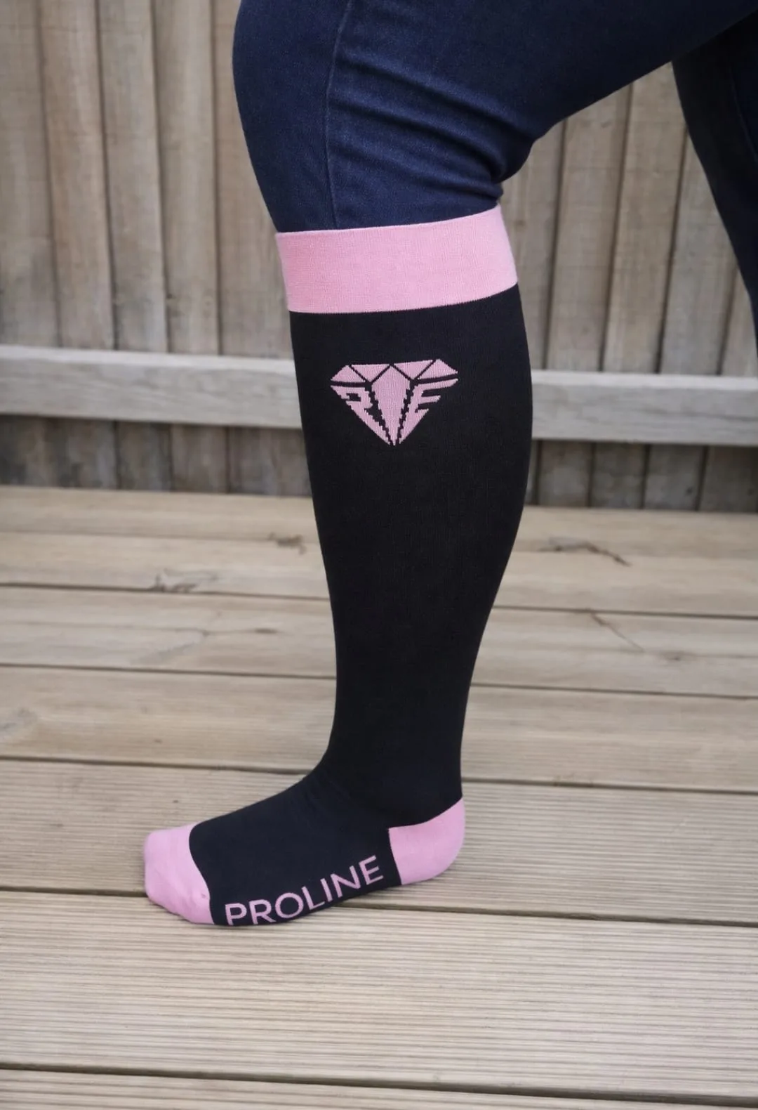 Freedom wide calf riding socks in black and pink, showing stretch fit and logo detail on the lower leg